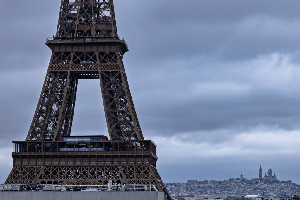 This photograph shows part of the Eiffel Tower with the Sacre-Coeur Basilica in the background, in Paris, on November 27, 2024. 