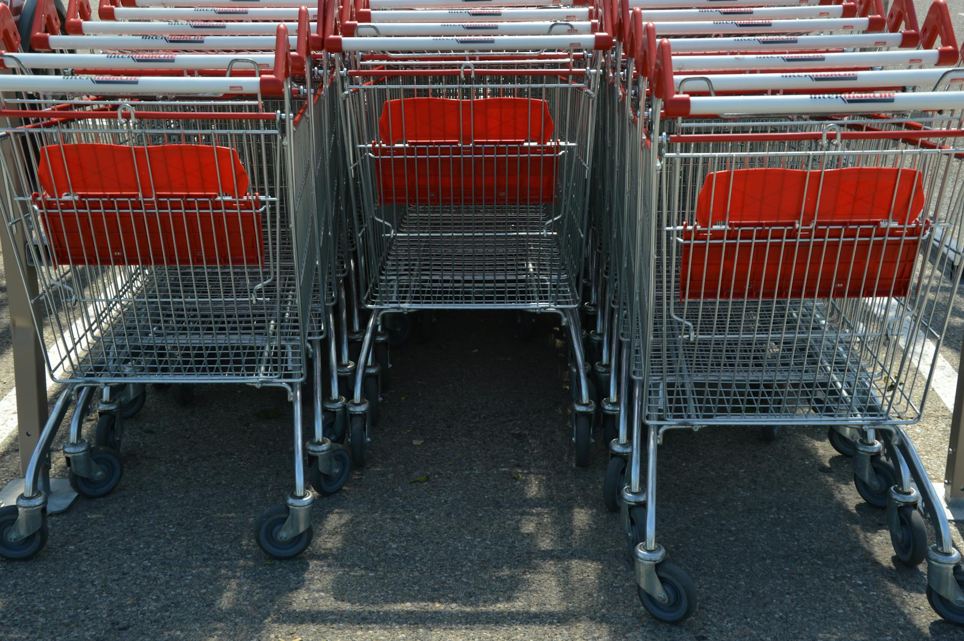 Shopping cart in grocery store aisle with shelves of products