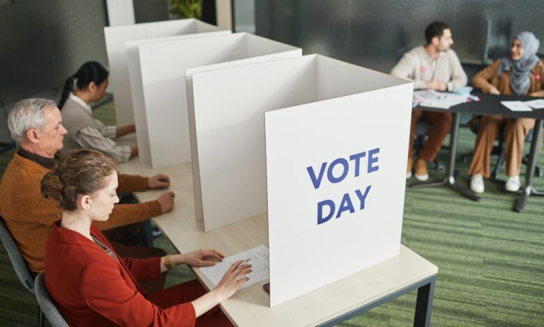 Person casting ballot in voting booth during primary election