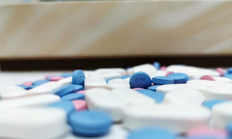 Pharmaceutical pills and tablets scattered on white surface representing generic drug market