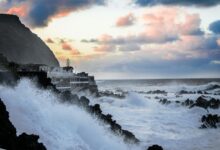 Coastal residential houses facing stormy weather conditions near the ocean