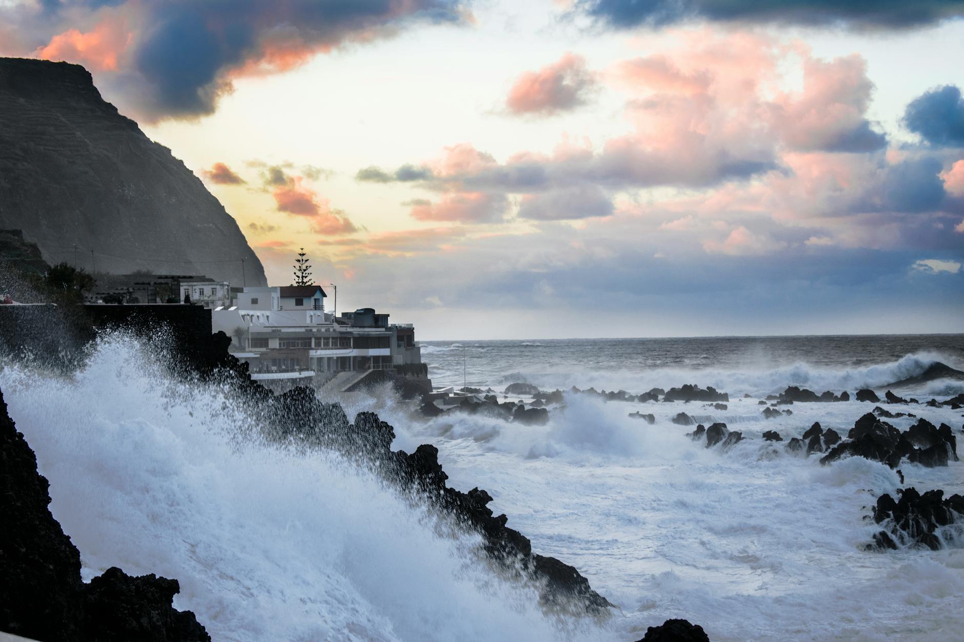 Coastal residential houses facing stormy weather conditions near the ocean