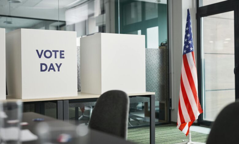 Person casting ballot in voting booth during election
