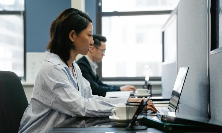 Professional office workers collaborating at modern workplace desks