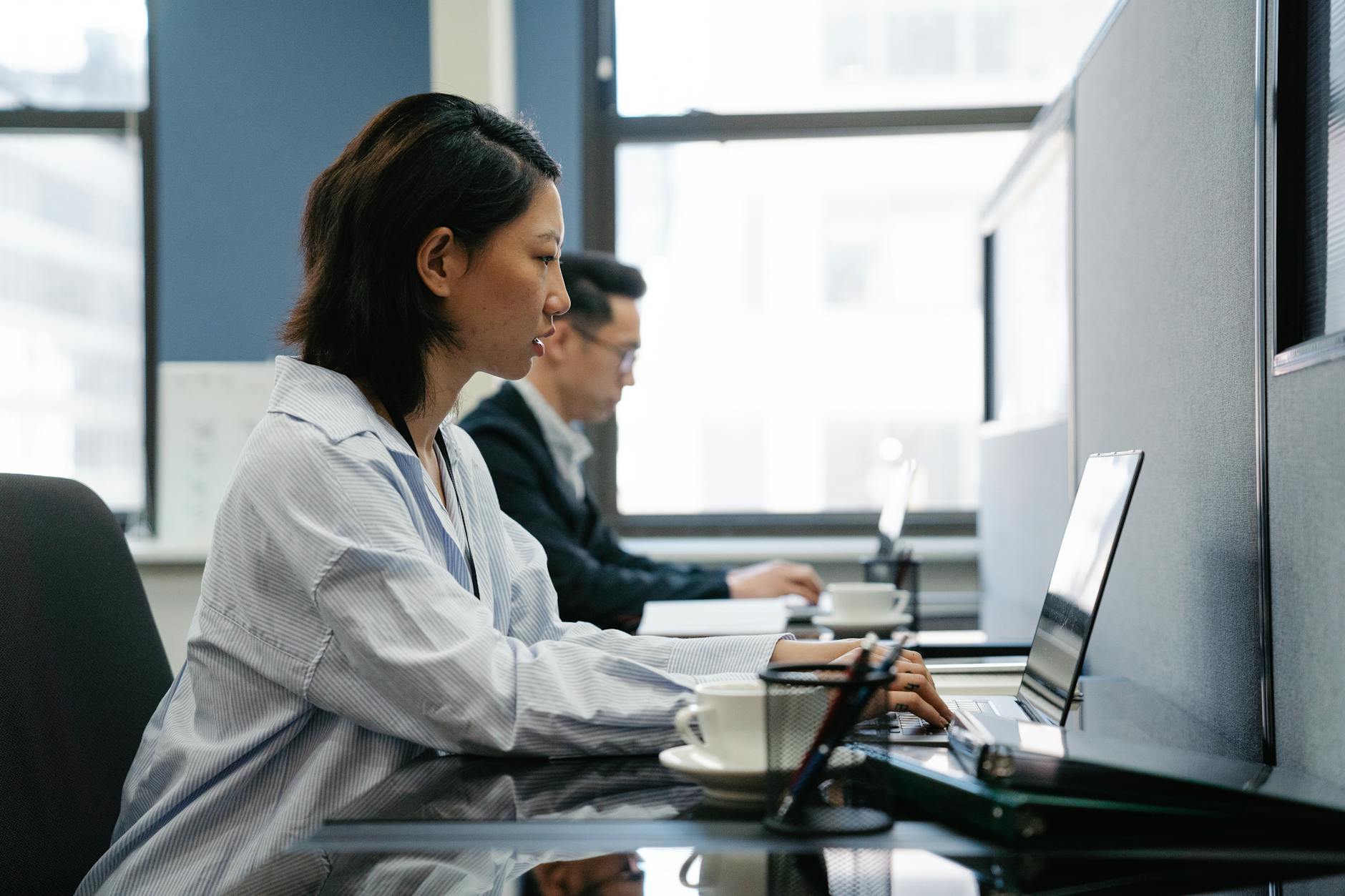 Professional office workers collaborating at modern workplace desks