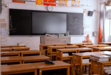 Empty classroom with rows of student desks highlighting teacher shortage crisis