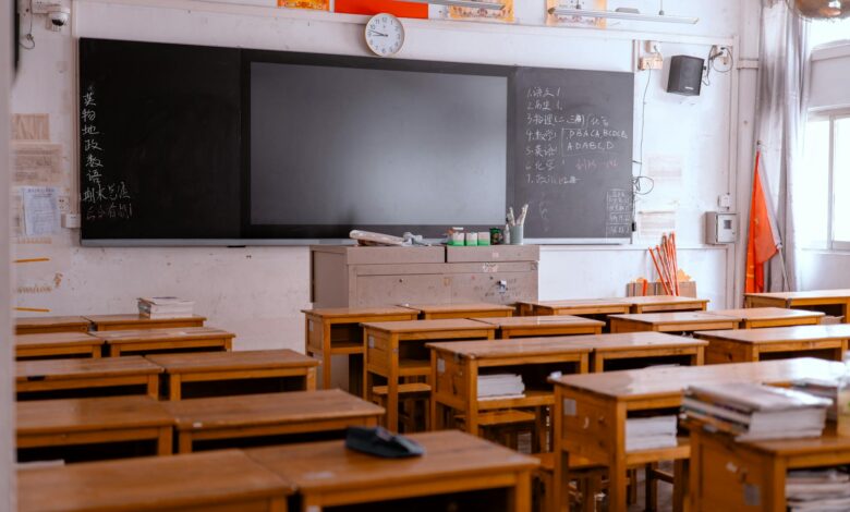 Empty classroom with rows of student desks highlighting teacher shortage crisis