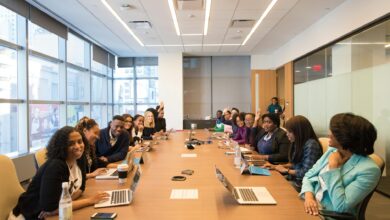 Professional meeting room with employees gathered around table during workplace presentation