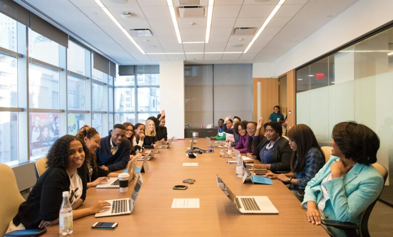 Professional meeting room with employees gathered around table during workplace presentation