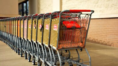 Shopping cart in grocery store aisle with shelves of products