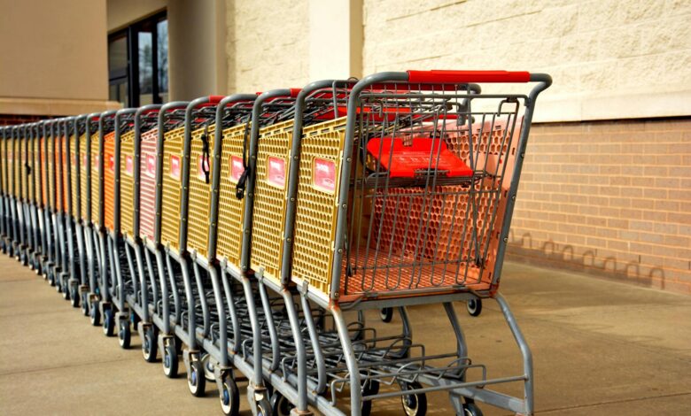 Shopping cart in grocery store aisle with shelves of products