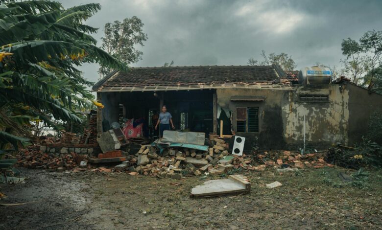 Damaged house with fallen tree and debris from severe storm showing insurance claim scenario