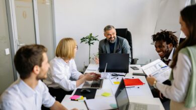 Professional office workers gathered around conference table in discussion