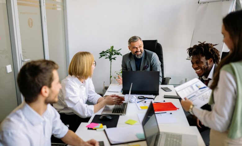 Professional office workers gathered around conference table in discussion