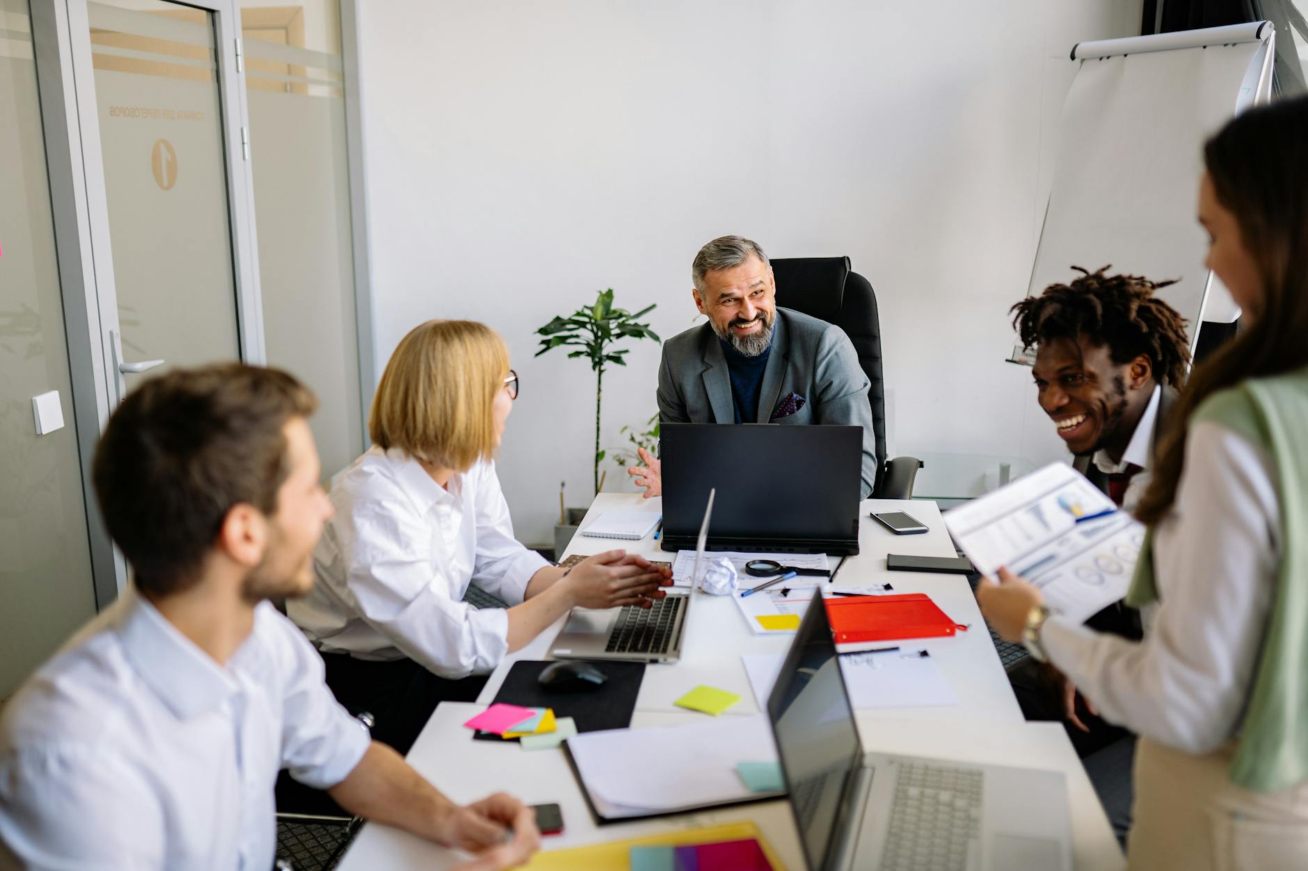 Professional office workers gathered around conference table in discussion