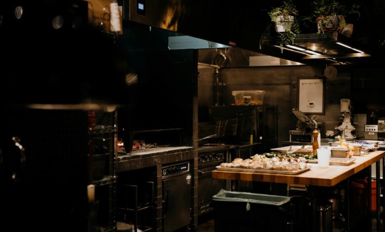 Modern commercial kitchen with stainless steel equipment and food preparation stations