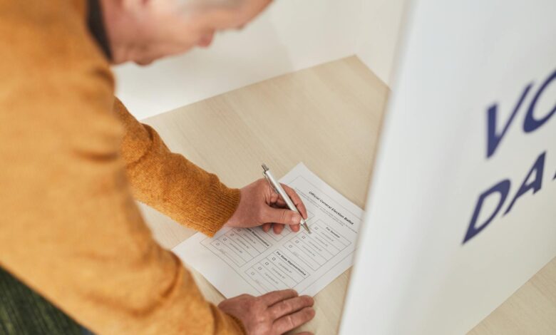Person casting ballot at voting booth during election