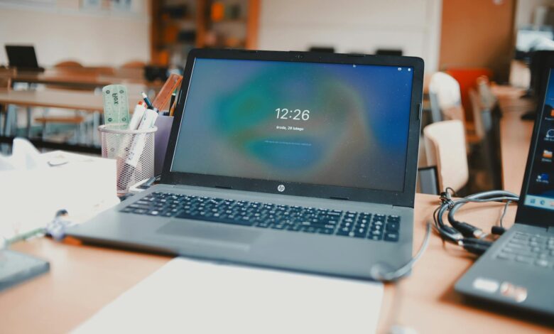 Laptop computer open in classroom setting showing remote learning technology interface
