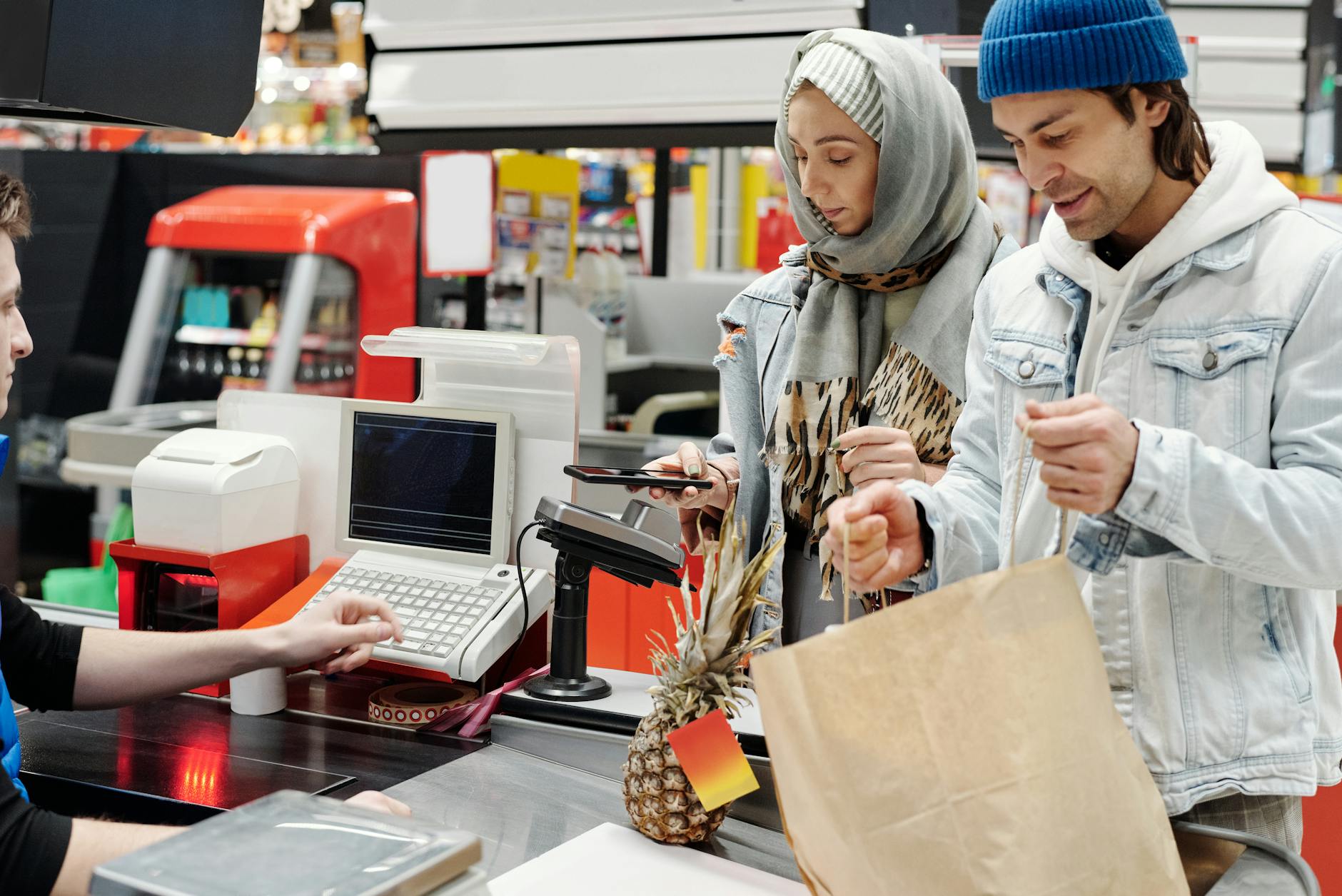 Modern grocery store checkout area with self-service kiosks and traditional cashier lanes