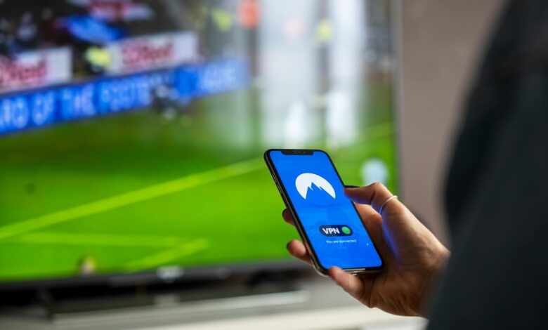 Person holding remote control watching streaming content on television screen