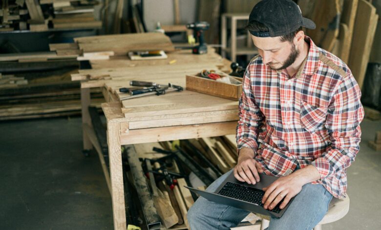 Small business owner working on laptop with AI tools and software applications