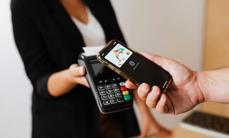Person using smartphone to make a mobile payment at checkout