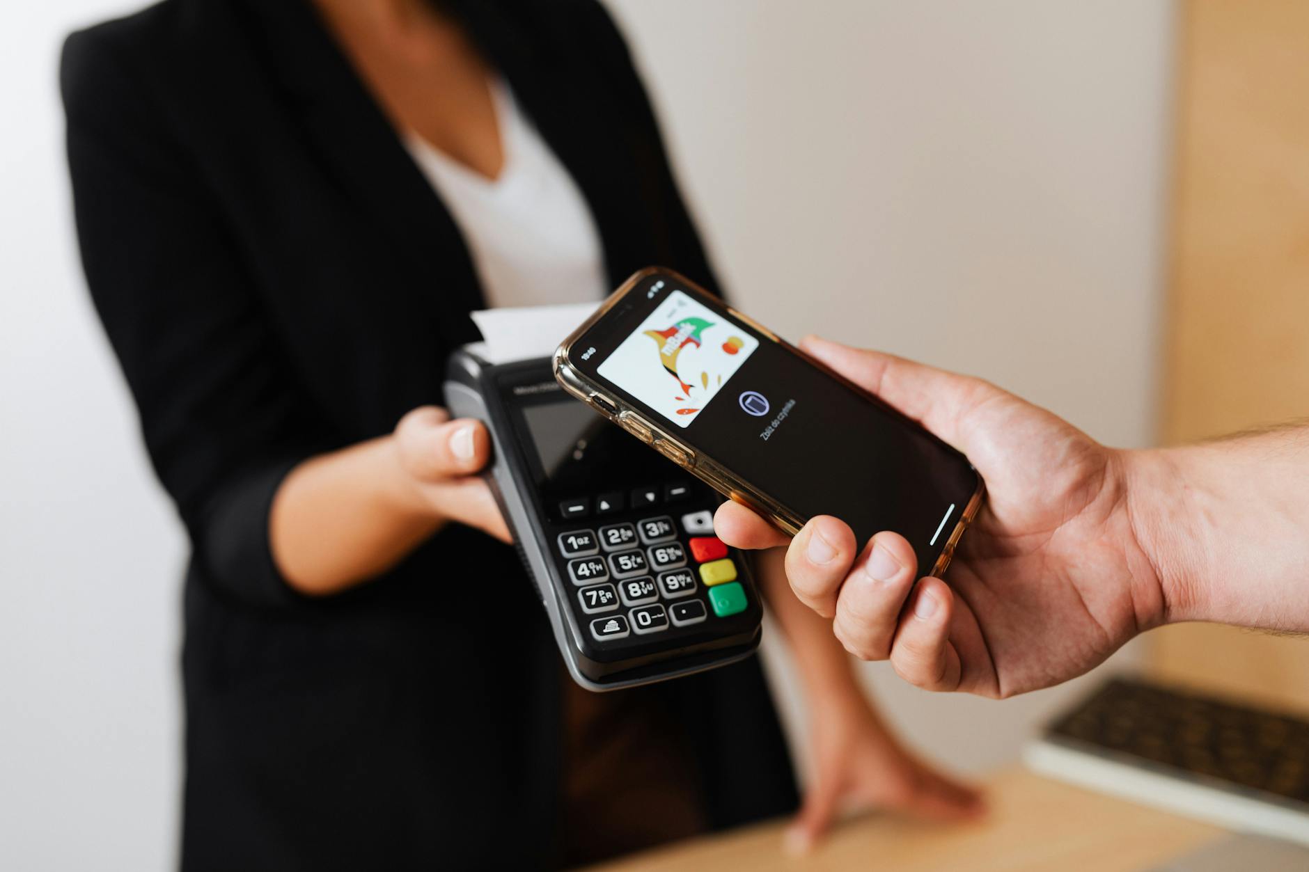 Person using smartphone to make a mobile payment at checkout