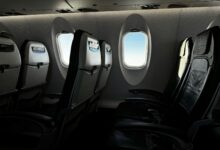 Modern aircraft cabin interior showing business class seating configuration with comfortable leather seats