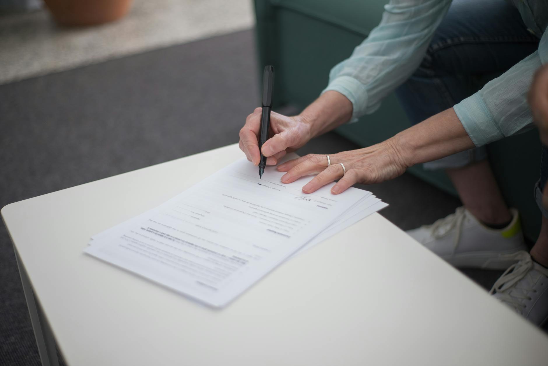 Hands signing petition document with pen on clipboard
