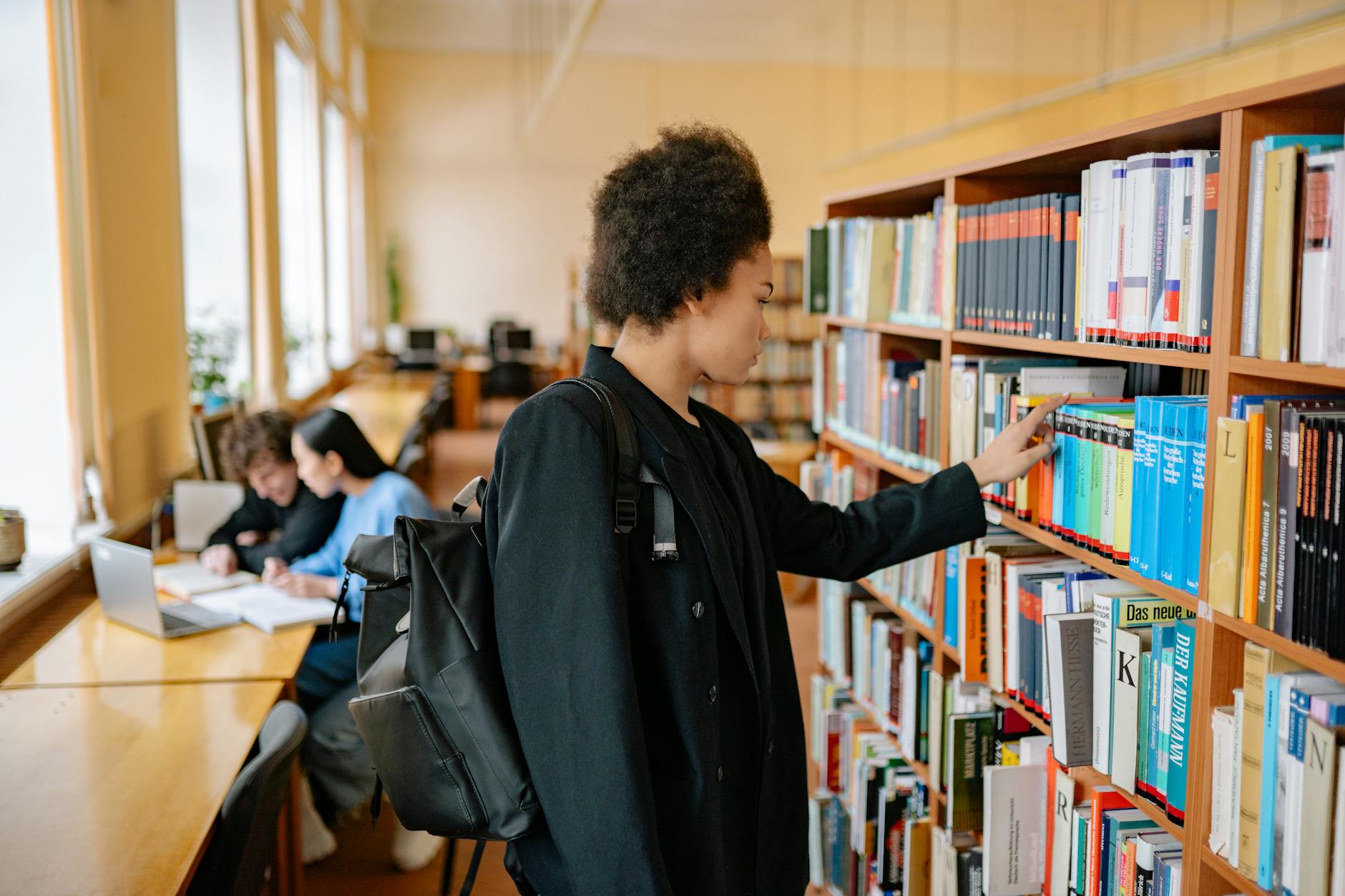 Students working together in a modern school library with computers and books