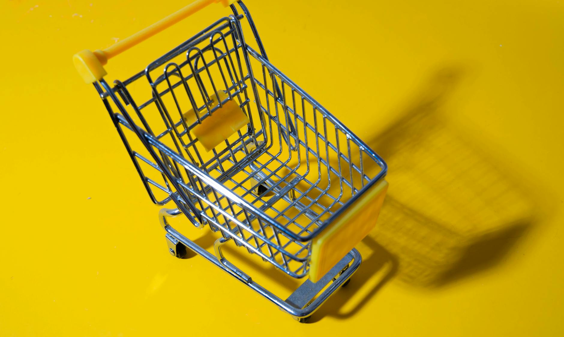 Shopping cart filled with various grocery items in store aisle
