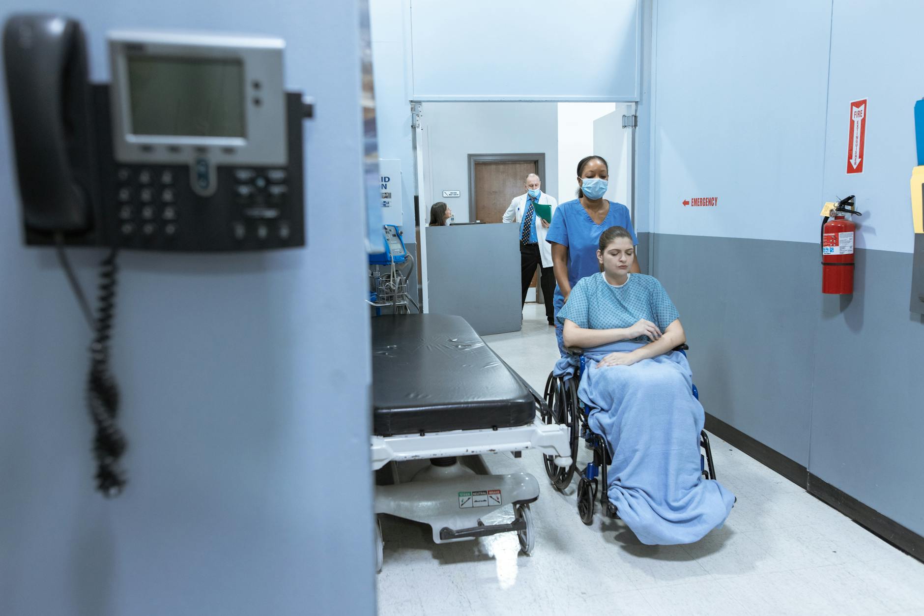 Empty hospital corridor with medical equipment and clean white walls
