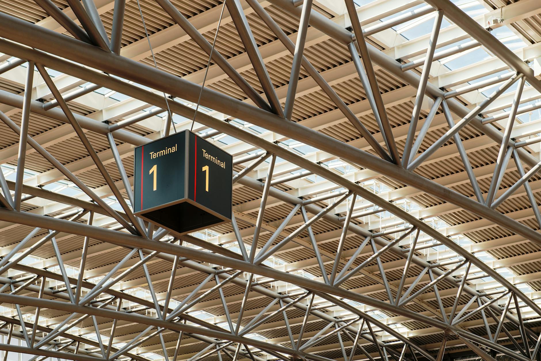 Busy airport terminal with passengers and flight departure boards showing domestic destinations