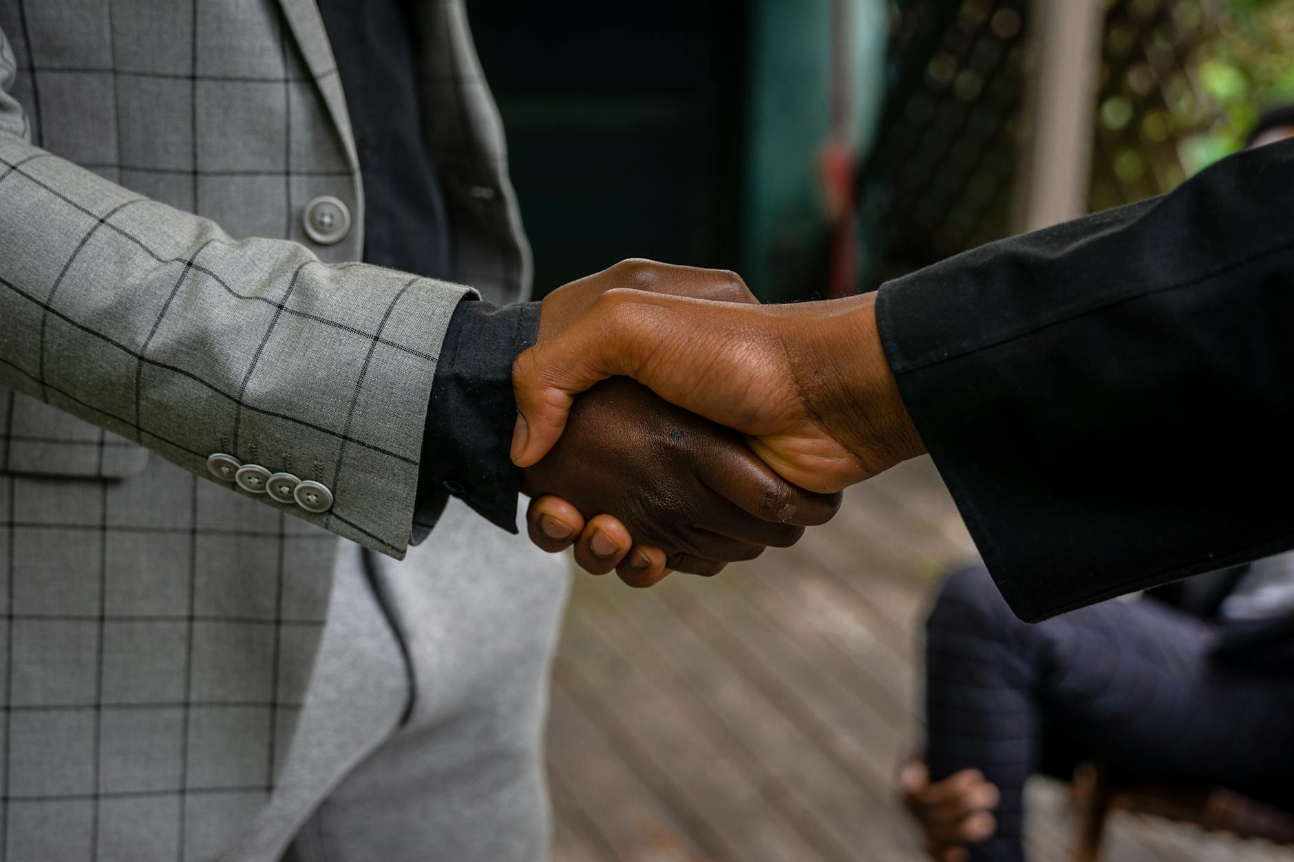 Business professionals shaking hands during contract negotiation meeting