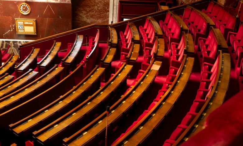 Empty Senate chamber with rows of wooden desks under a domed ceiling