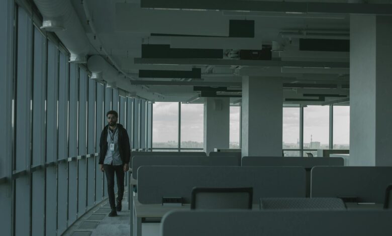 Vacant commercial office building exterior with empty floors visible through glass windows