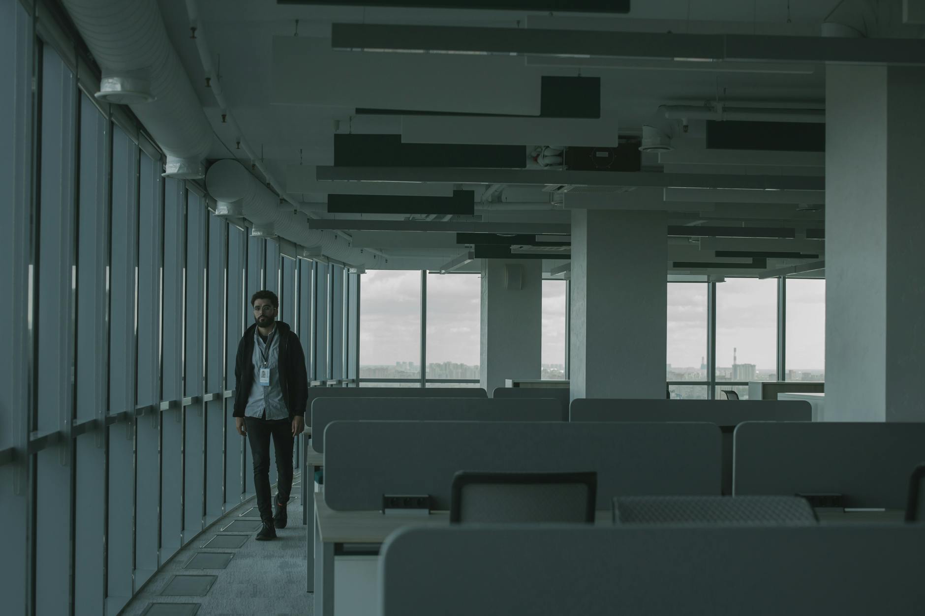 Vacant commercial office building exterior with empty floors visible through glass windows