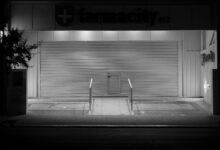 Empty retail pharmacy interior with vacant shelves and closed counter