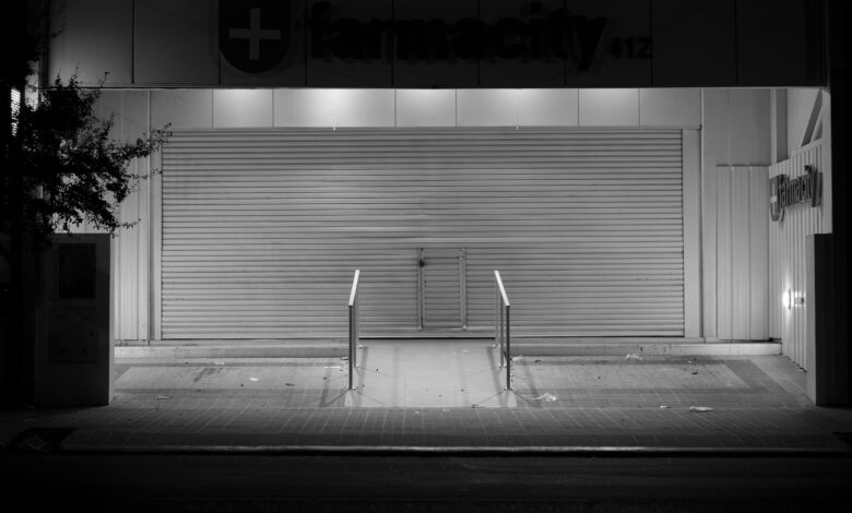 Empty retail pharmacy interior with vacant shelves and closed counter