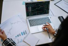 Financial advisor reviewing investment portfolio at a desk with multiple monitors