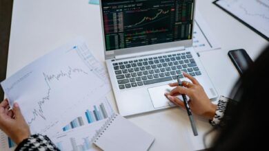 Financial advisor reviewing investment portfolio at a desk with multiple monitors