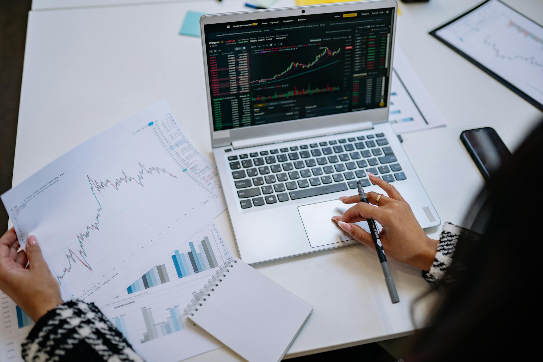 Financial advisor reviewing investment portfolio at a desk with multiple monitors