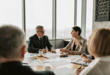 Business professionals reviewing financial documents at a corporate meeting table