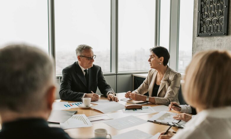 Business professionals reviewing financial documents at a corporate meeting table