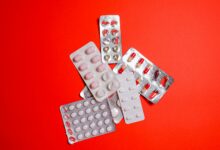 Rows of prescription medications on pharmacy shelves representing specialty drug distribution