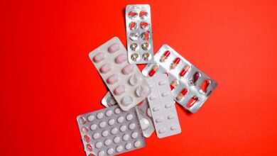 Rows of prescription medications on pharmacy shelves representing specialty drug distribution