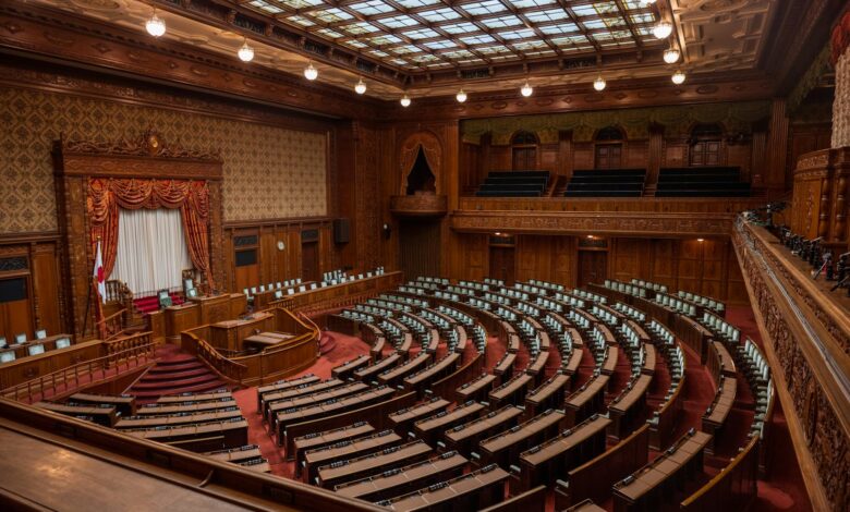 Empty senate chamber with rows of desks and American flag