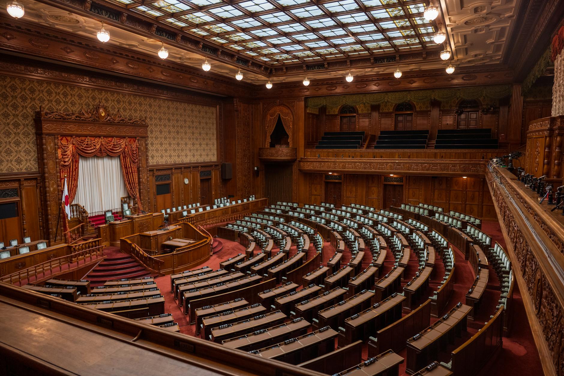 Empty senate chamber with rows of desks and American flag