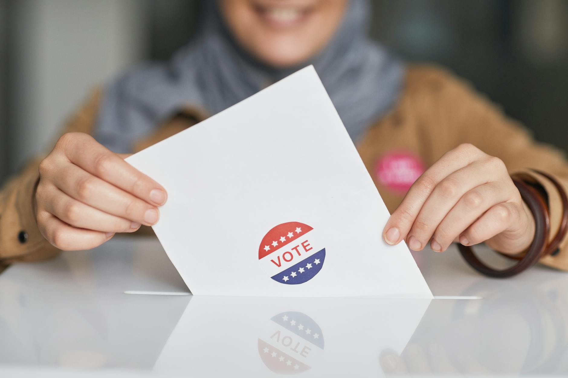 Ballot box with voting forms being inserted by voters