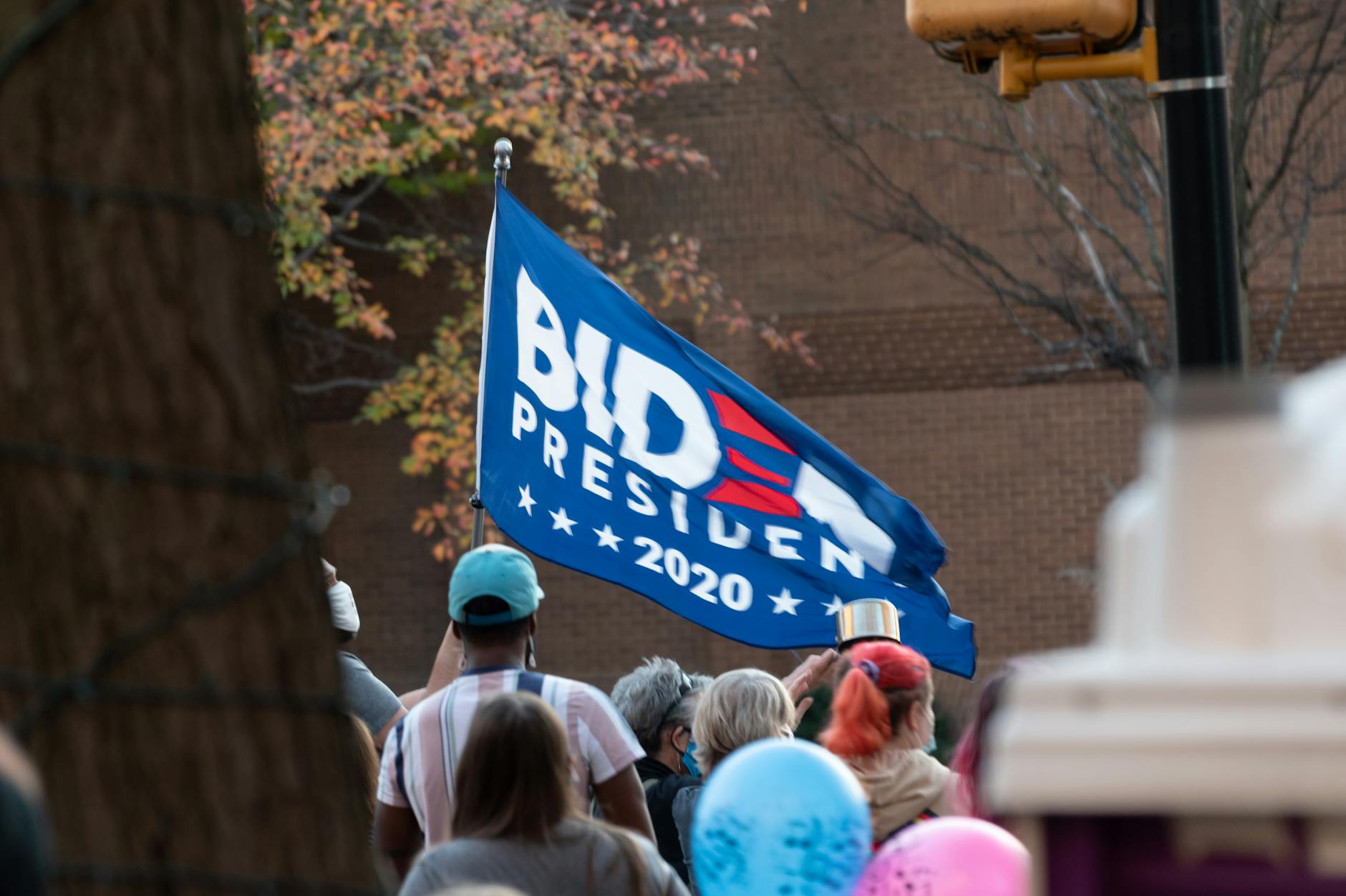 Political candidate speaking at podium during campaign event with supporters